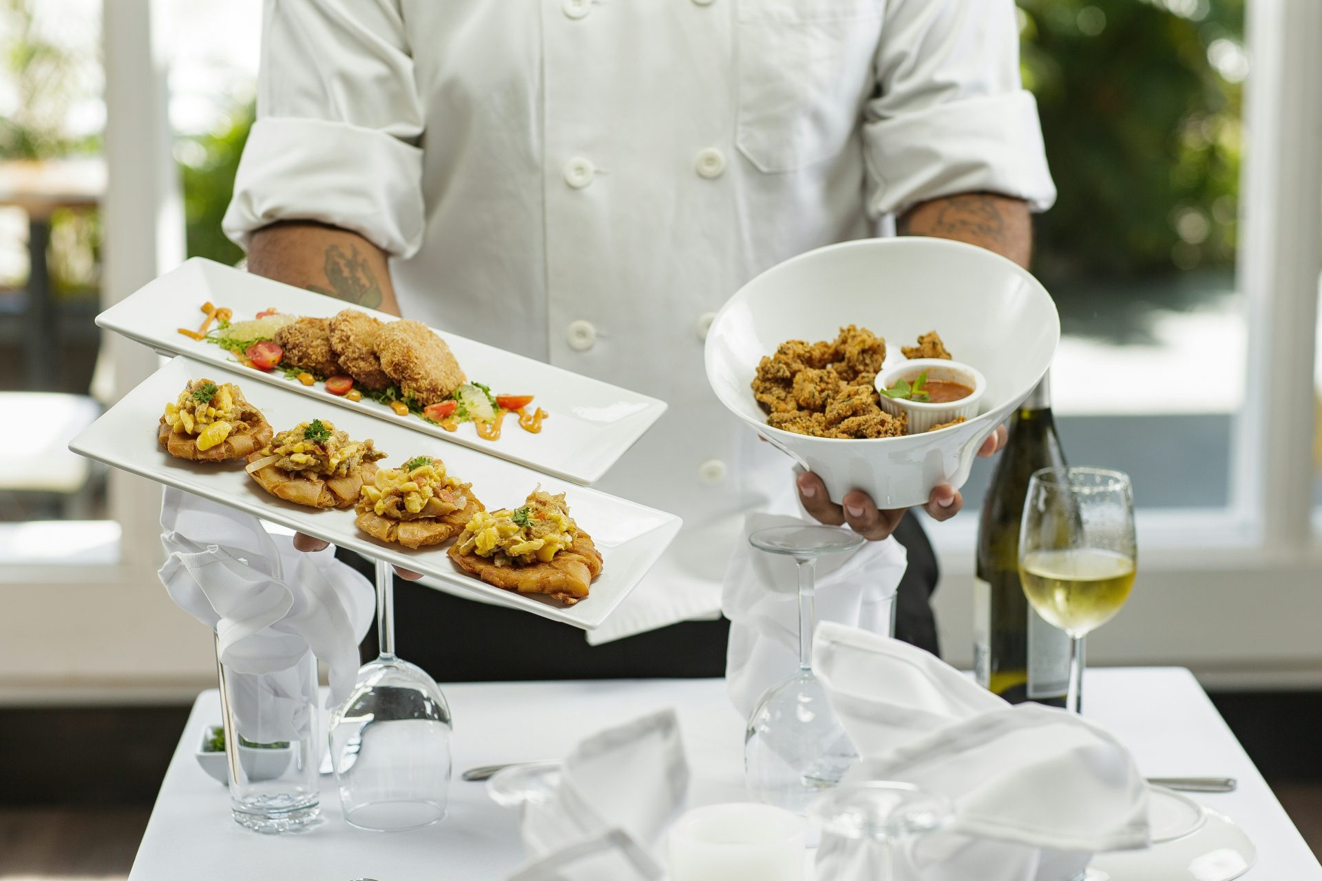Person in weißem Oberhemd hält eine weiße Keramikschale mit Essen.